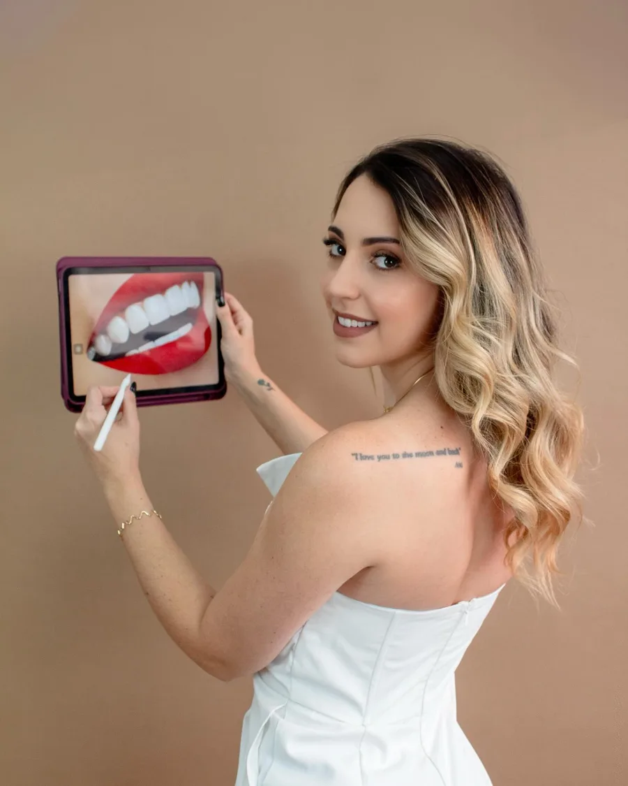 Dra. Júlia mostrando a foto de um sorriso em um tablet
